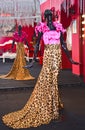 Mannequins standing in long line along the street market wearing colorful cloths Woman Leopard colored and pink