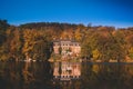 Manor house in autumn forest on the lake with reflection Royalty Free Stock Photo