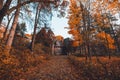 Manor house with trees in autumn colors and fall trees. Old Victorian Haunted House with ghosts. Abandoned house in autumn wood