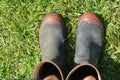 Mans gardening gumboots on green grass