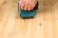 Mans hand on belt sander on pine wood Royalty Free Stock Photo