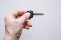 Mans hand with blank key on a grey background