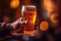 a mans hand clutches a satisfying glass of beer in a cozy pub. Royalty Free Stock Photo