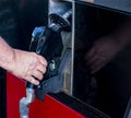 Mans hand grasping nozzle of gas pump to remove it to fill up vehicle with gas Royalty Free Stock Photo