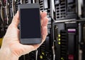 Mans hand holding mobile phone in server room Royalty Free Stock Photo
