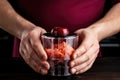 mans hand holding a pomegranate half, ready to squeeze in a juicer