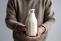 Mans Hand Holds Bottle Of Milk Against White Background. Generative AI