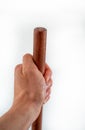 Mans hand holds brown wooden haft on white background Royalty Free Stock Photo