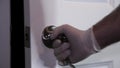 A mans hand in latex gloves opening a door. 24FPS HD.