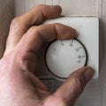 Man operates central heating thermostat Royalty Free Stock Photo