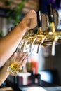 Mans hand pouring pint of beer behind the bar in pub Royalty Free Stock Photo