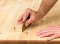 Mans hand on sanding block on pine wood Royalty Free Stock Photo