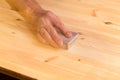 Mans hand on sanding block on pine wood Royalty Free Stock Photo