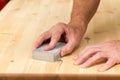 Mans hand on sanding block on pine wood Royalty Free Stock Photo
