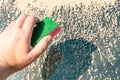 A Mans hand with sponge cleaning a car's windshield in sunny day. Early spring washing or regular wash up.Car wash by hands. Royalty Free Stock Photo