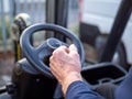 Mans hand on the steering wheel of a fork lift truck in the work place Royalty Free Stock Photo