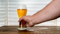 Mans hand is taking beer inside glass on