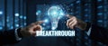 Mans hand touching exploding light bulb with BREAKTHROUGH text, symbolizing innovation, idea generation, and technological Royalty Free Stock Photo