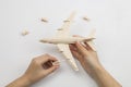 Mans hands assembling wooden airplane toy