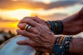 mans hands with boho wristbands playing bongos at sunset Royalty Free Stock Photo
