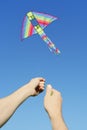 Mans hands flying multicolored kite Royalty Free Stock Photo