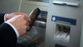 Mans hands putting dollars in wallet, cash withdrawn from ATM, travelling abroad