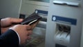Mans hands putting Russian rubles in wallet, cash withdrawn from ATM, travelling