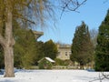 A mansion house and gardens on a sunny winter day