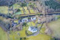 Mansion and private tennis court in real estate grounds aerial view from above