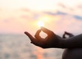 Mantra yoga meditation practice with silhouette of woman in lotus pose having peaceful mind relaxation on the beach