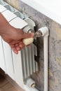 Manual adjustment of the valve on a heating radiator in a house Royalty Free Stock Photo