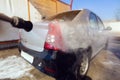 Manual car wash with pressurized water in car wash outside. Concept of summer car washing and cleaning car using high