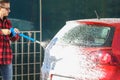 Manual car wash with pressurized water in car wash outside.Summe Washing. Cleaning Car Using High Pressure Water. Royalty Free Stock Photo