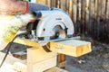 Manual circular circular saw on wood metabo. A man at a construction site saws a wooden Board bar close-up. The concept