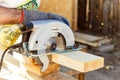 Manual circular circular saw on wood metabo. A man at a construction site saws a wooden Board bar close-up. The concept of working