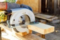 Manual circular circular saw on wood metabo. A man at a construction site saws a wooden Board bar close-up. Woodworking equipment