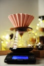 Manual coffee brewing with origami dripper in Christmas interior.