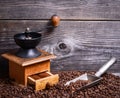 Manual coffee grinder with beans and vintage scoop on wooden background Royalty Free Stock Photo