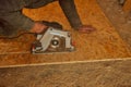 Manual electric circular saw cuts a wooden plate.