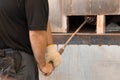 Manual glass production by glassblowing by worker at the factory. Man holding a vase in a muffle furnace Royalty Free Stock Photo