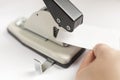 Manual hole punch for installing metal sleeves or eyelets. white tag in hand