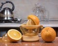 Manual juice extractor. Juicing oranges. Electric press juicer with cut orange on kitchen table Royalty Free Stock Photo