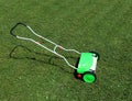 Manual lawn mower under the sun on a freshly cut meadow