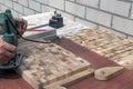 A carpenter with a hand-held electric milling cutter makes an end cutting board Royalty Free Stock Photo