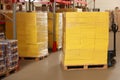 Manual pallet truck with stacked boxes in warehouse. Wholesaling