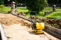 A manual paver evens out the top layer of sand