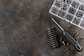 Manual screwdriver, drill bits and assorted screws on dark textured table. DIY home tools. Top view. Copy space. Royalty Free Stock Photo