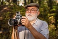 Manual settings. Pension hobby. Experienced photographer. Old man shoot nature. Cameraman retirement. Professional Royalty Free Stock Photo