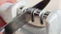 Manual sharpening of a knife in a special sharpener Royalty Free Stock Photo