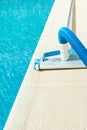 Manual Swimming Pool Vacuum Cleaner on Stone Deck. Bright Summer Sunny Day. Maintenance Cleaning Service Concept